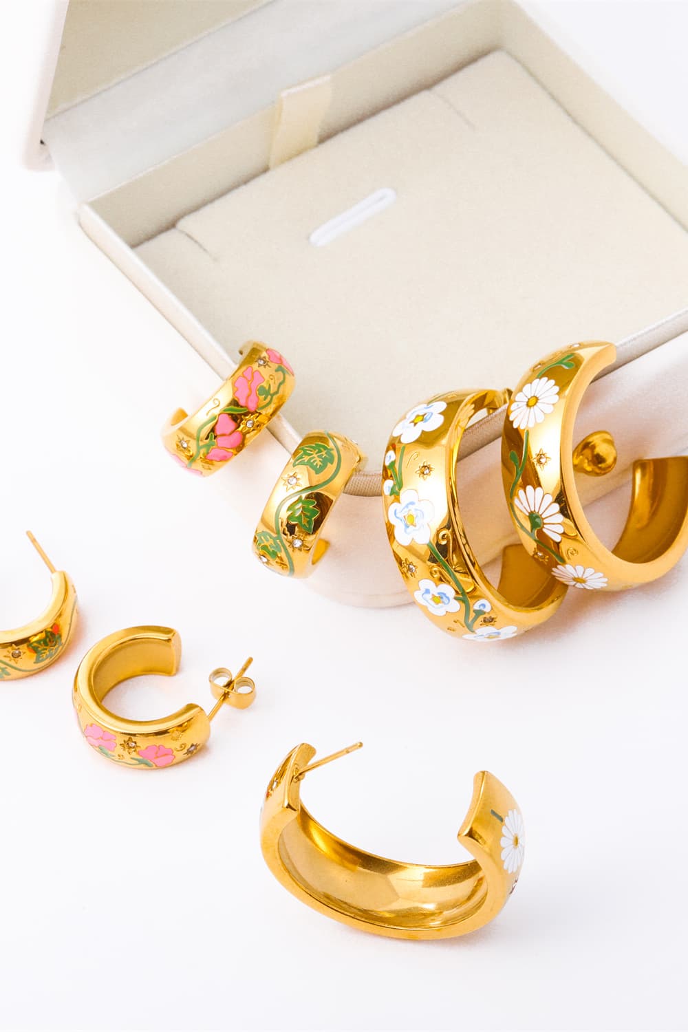 Set of colorful 18K gold plated hoop earrings in a jewelry box with floral designs