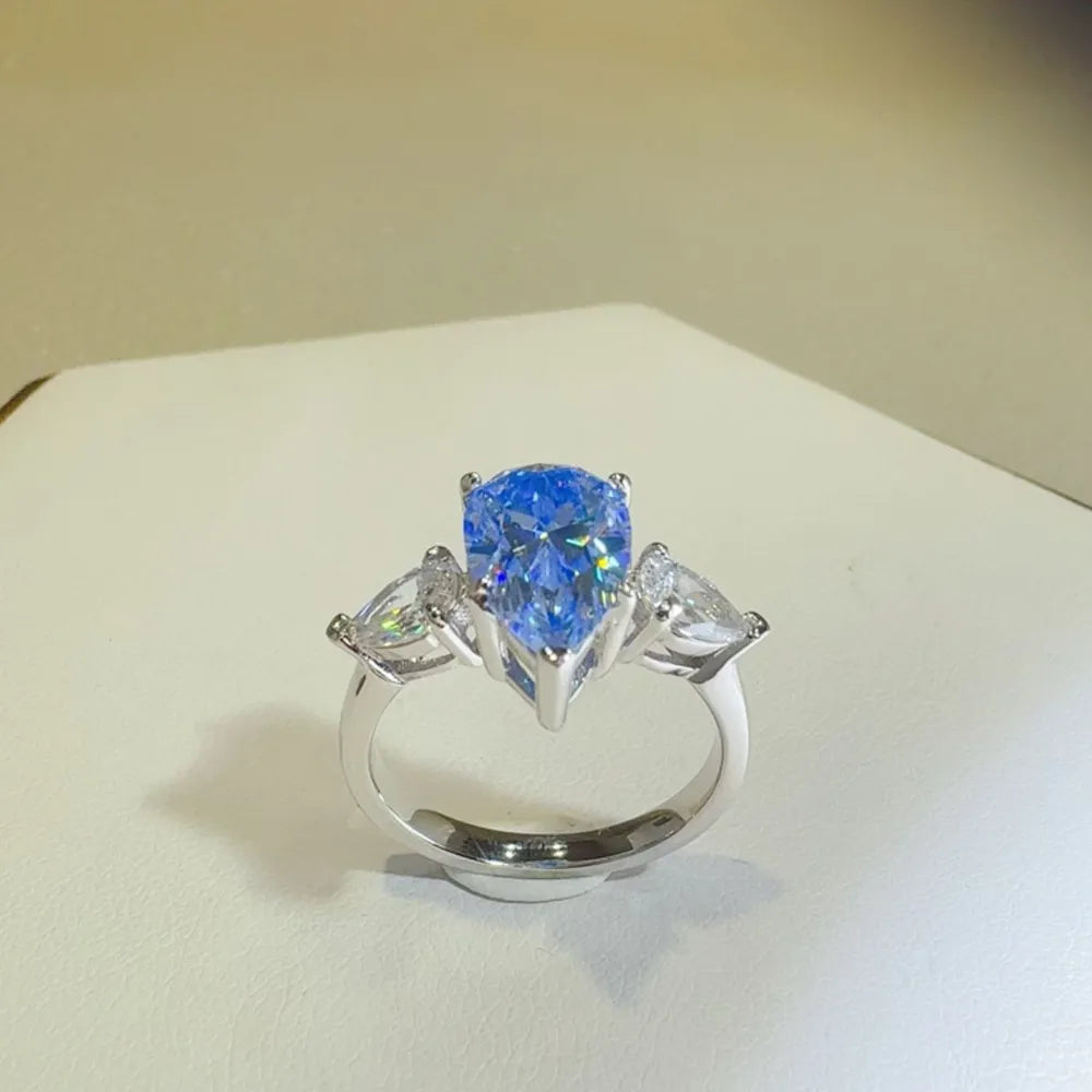 Elegant 2 carat moissanite teardrop ring with side stones in a polished silver band