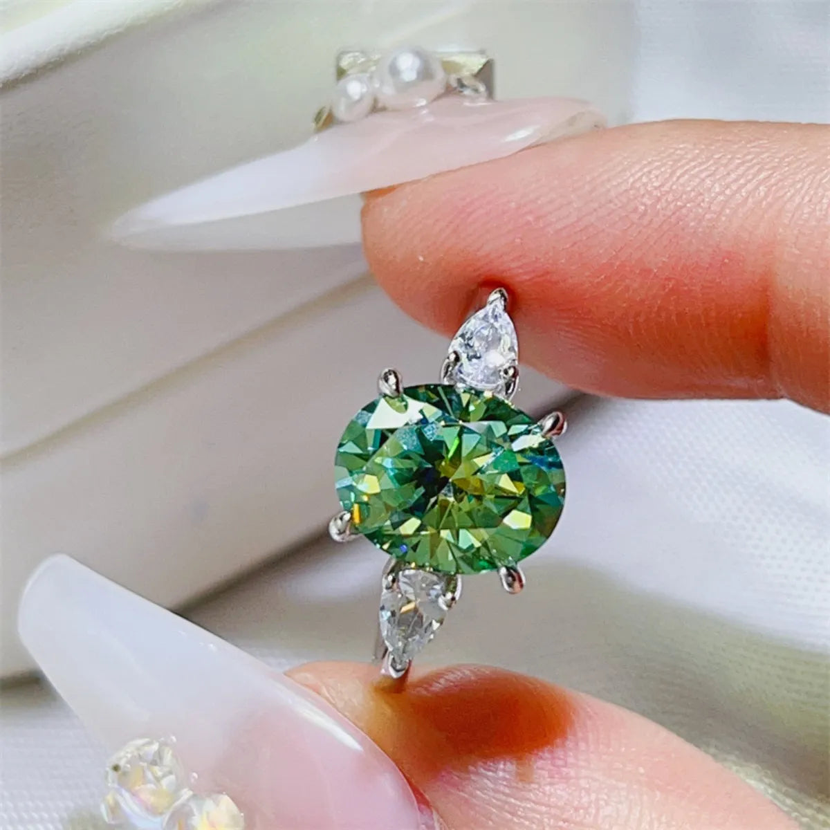Elegant 3 carat moissanite ring showcased on a hand, featuring a vibrant green stone