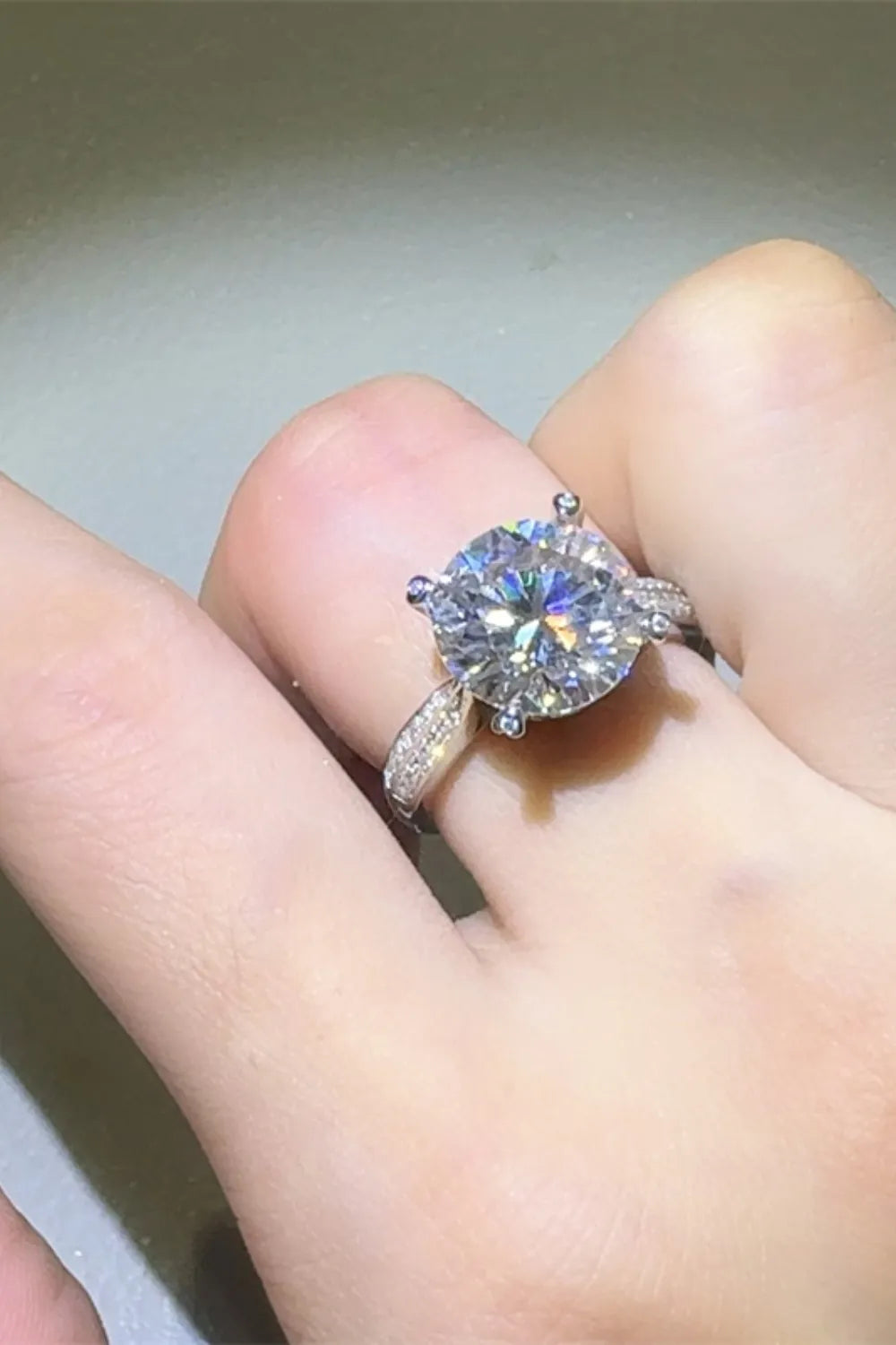 Elegant 5 carat moissanite ring set on a hand with sparkling side diamonds