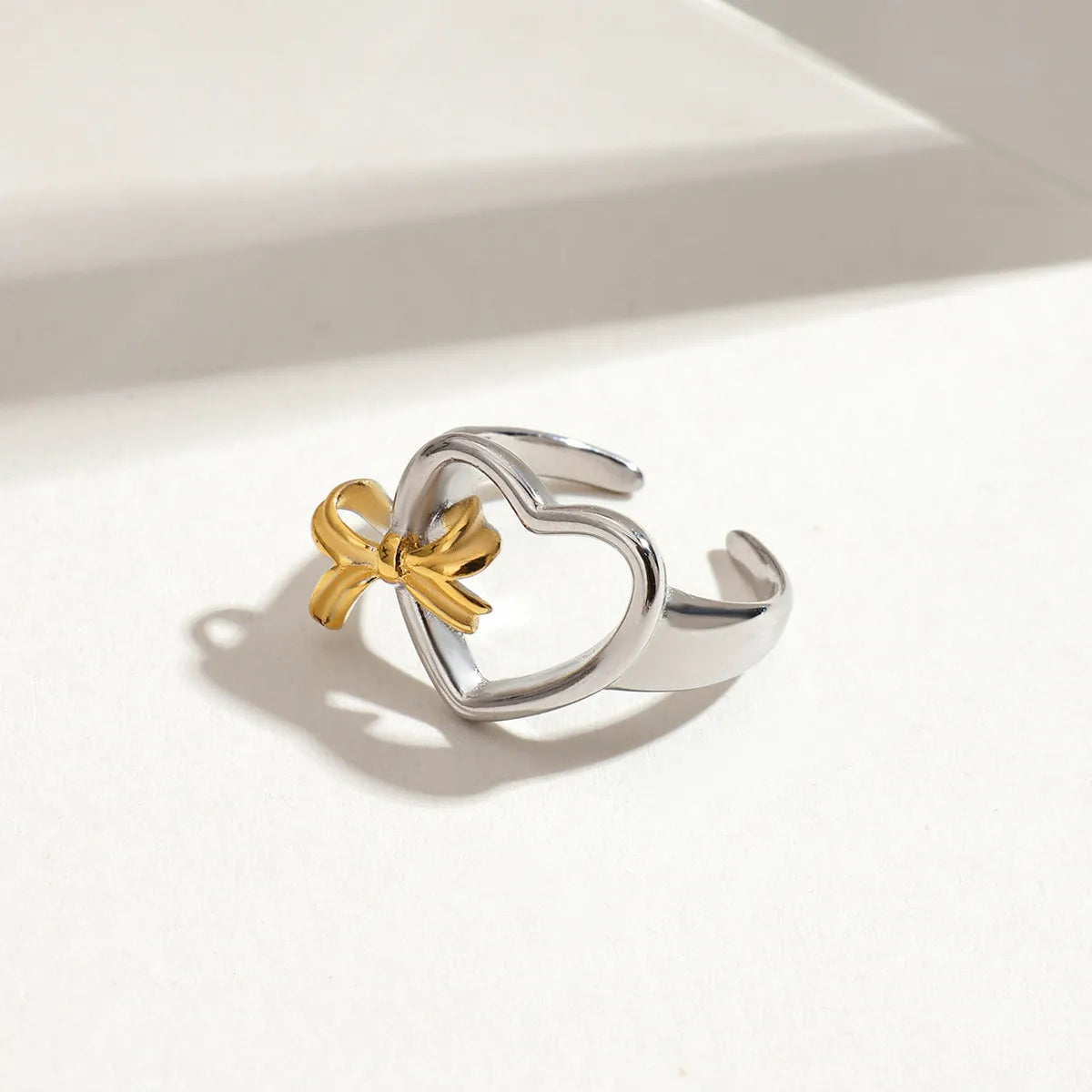 Trendsi adjustable two-tone heart ring featuring a silver heart design and a gold bow detail