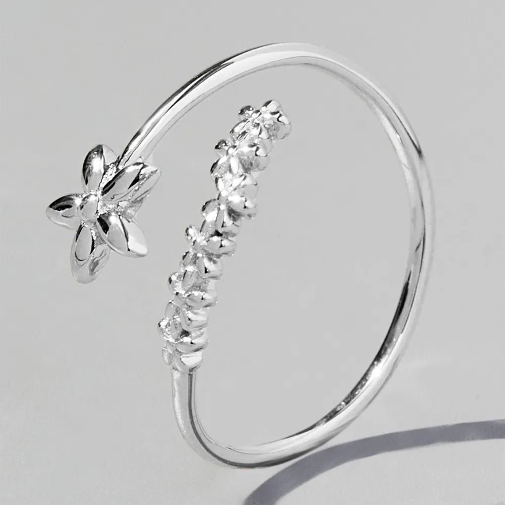 Delicate floral silver ring designed with a flower detail and shimmering stones for elegance