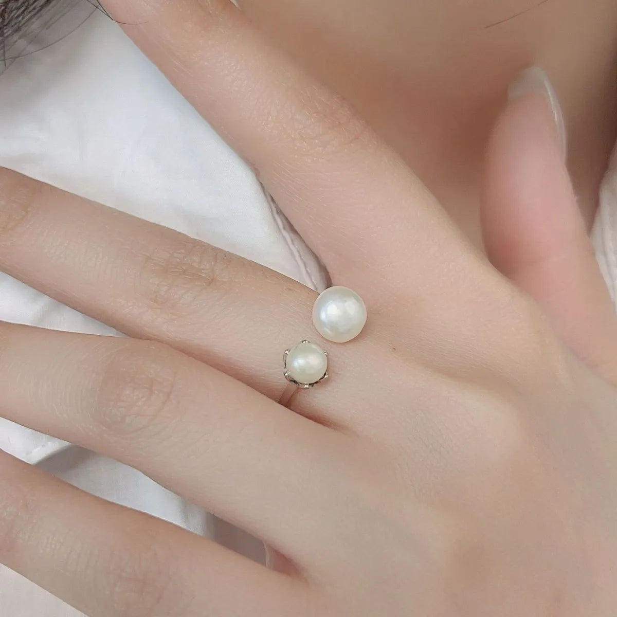 Trendy elegant pearl jewelry set featuring two stylish pearl rings on a delicate hand