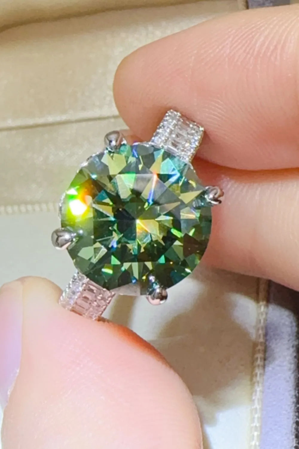 Close-up of a glamorous green gemstone ring with sparkling details and a silver band