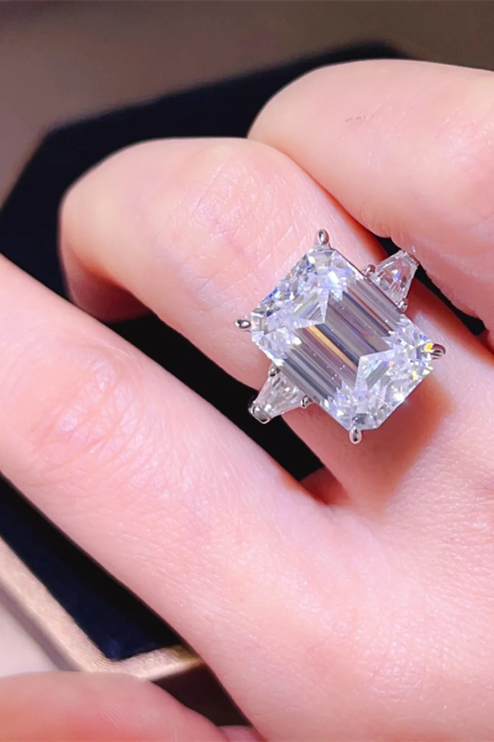 Stunning luxury moissanite jewelry ring featuring a large emerald cut stone on a delicate band