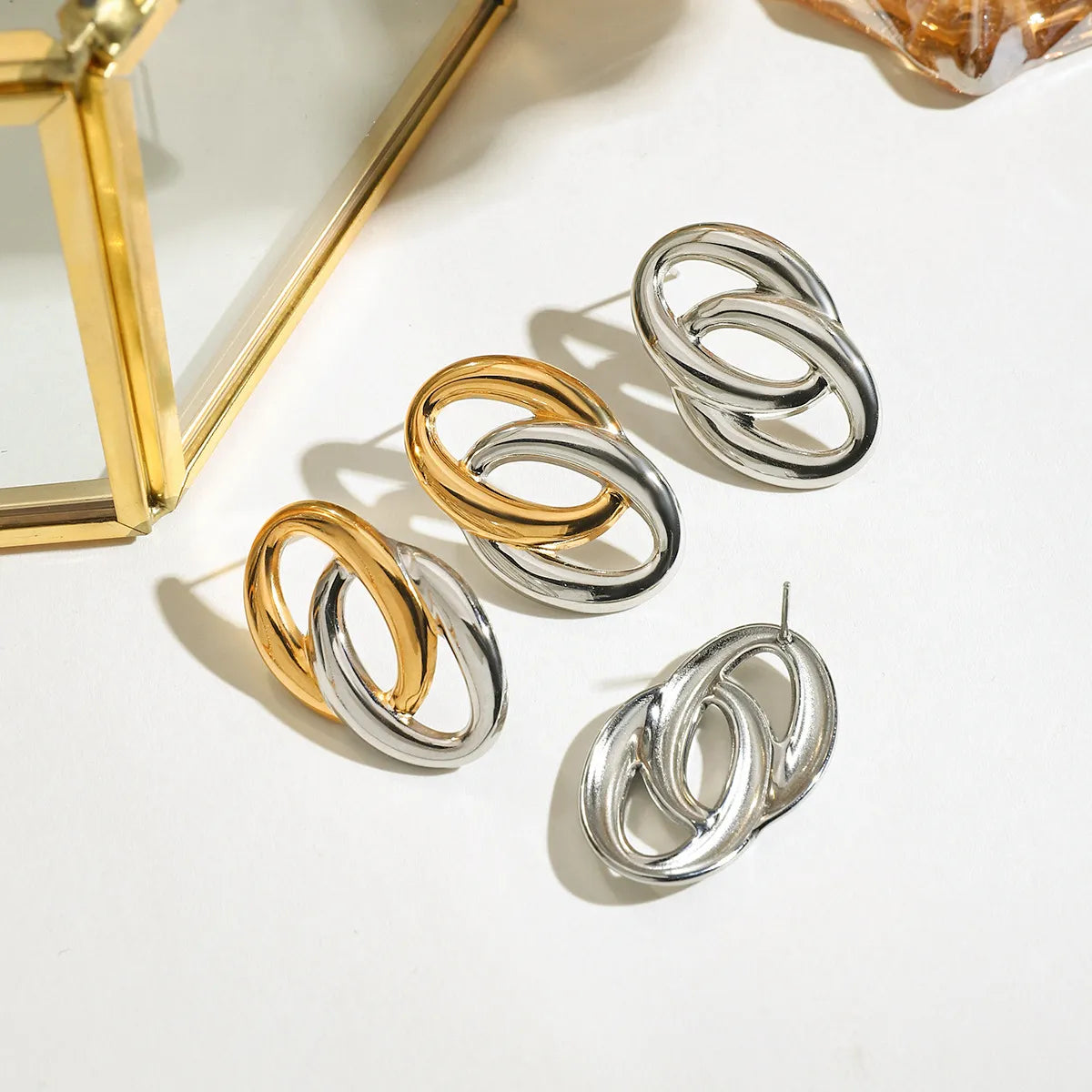 Trendy modern twist hoop earrings in gold and silver with a stylish design for versatile looks