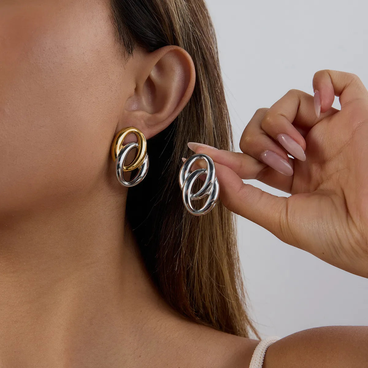Trendy modern twist hoop earrings in gold and silver for a stylish accessory look