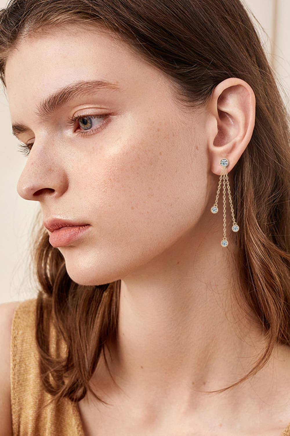 Elegant moissanite drop earrings showcased on a model with a sleek hairstyle and subtle makeup