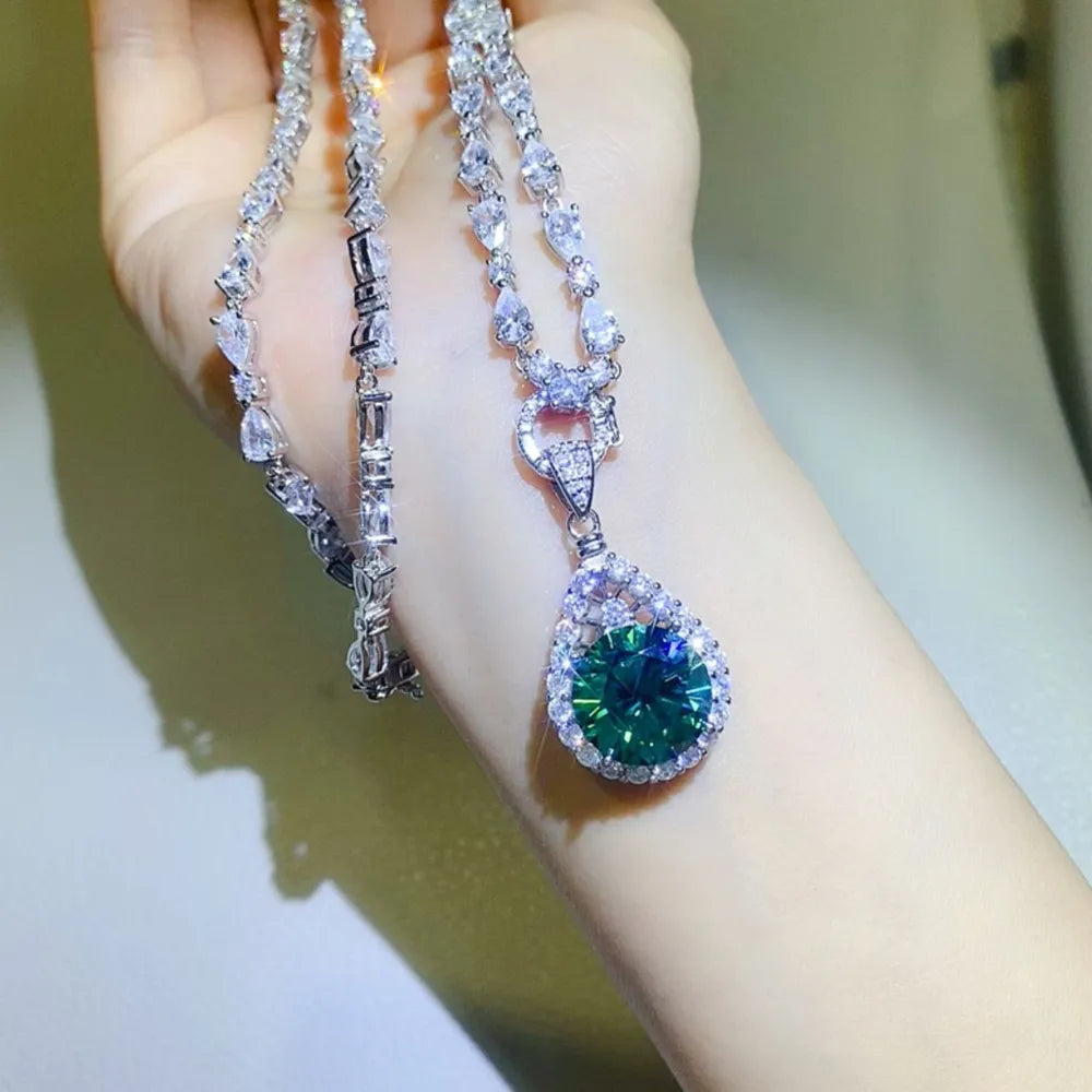 Elegant Teardrop Moissanite Pendant showcased on a sparkling necklace with a stunning green stone