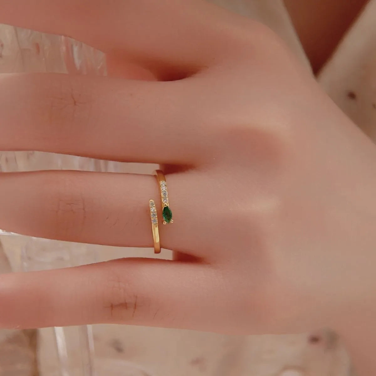 Trendy adjustable ring featuring a delicate design with a green stone and sparkling accents