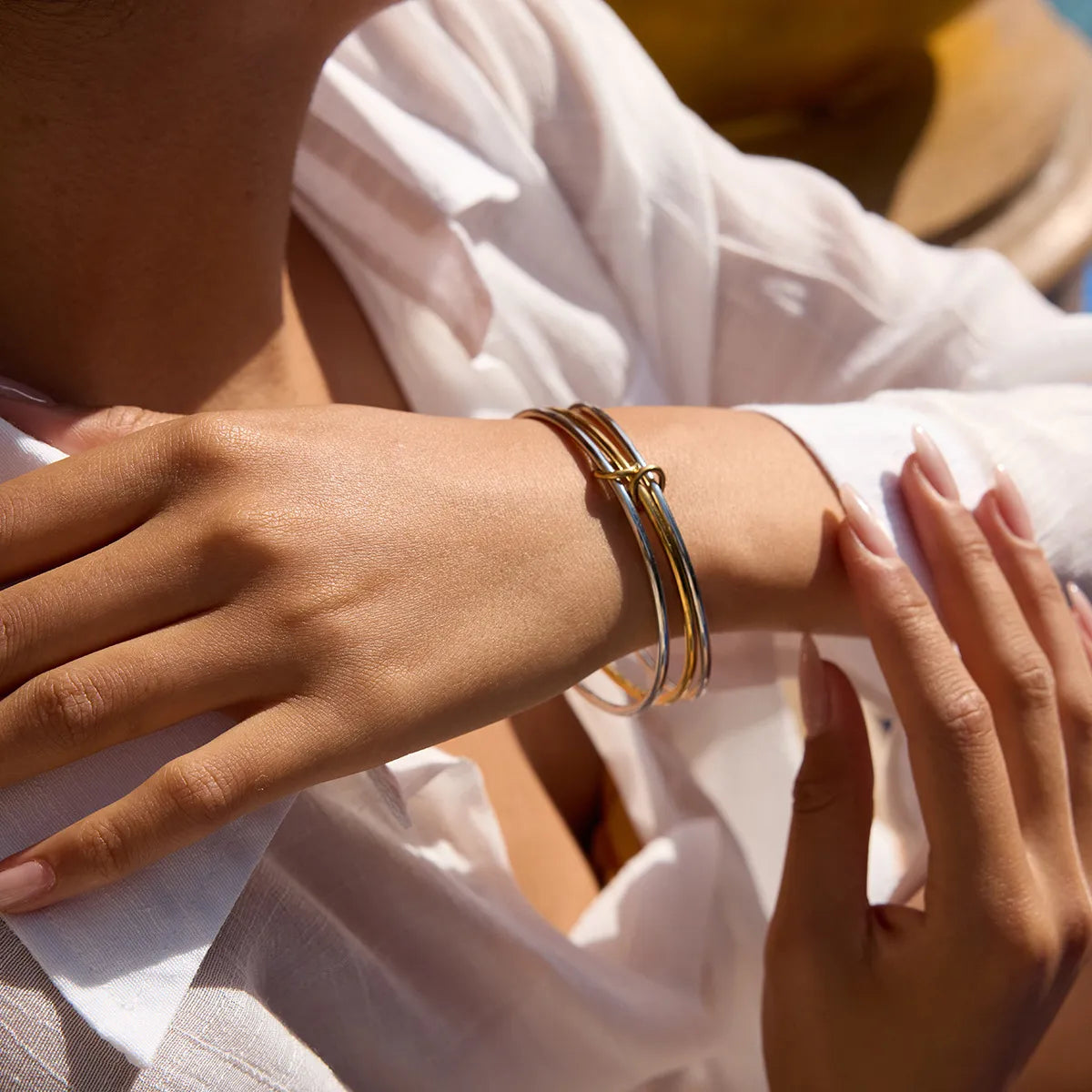 Stylish two-tone bangle bracelet showcased on a woman's wrist with elegant design