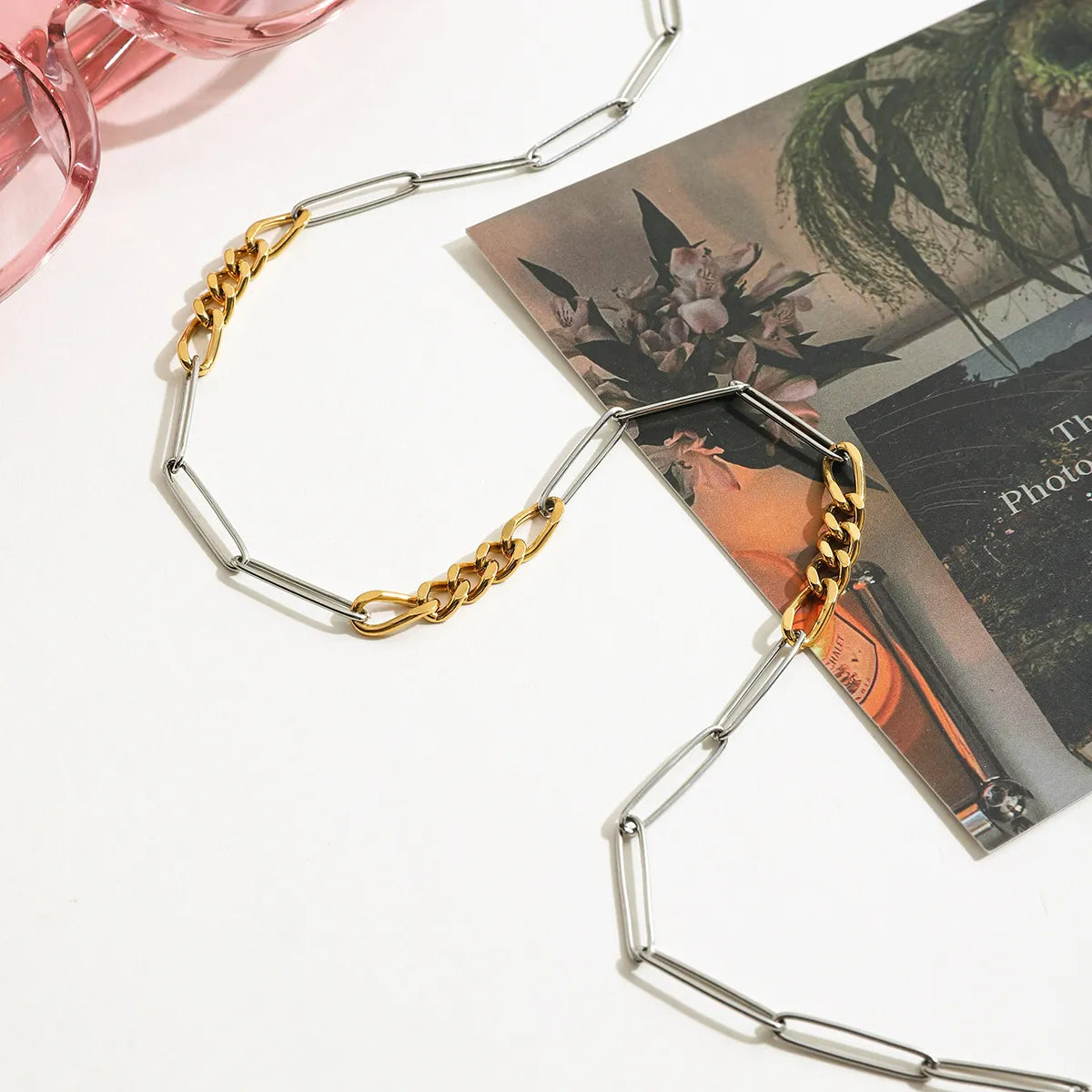 Trendsi two-tone chain link necklace displayed with pink sunglasses and floral print card
