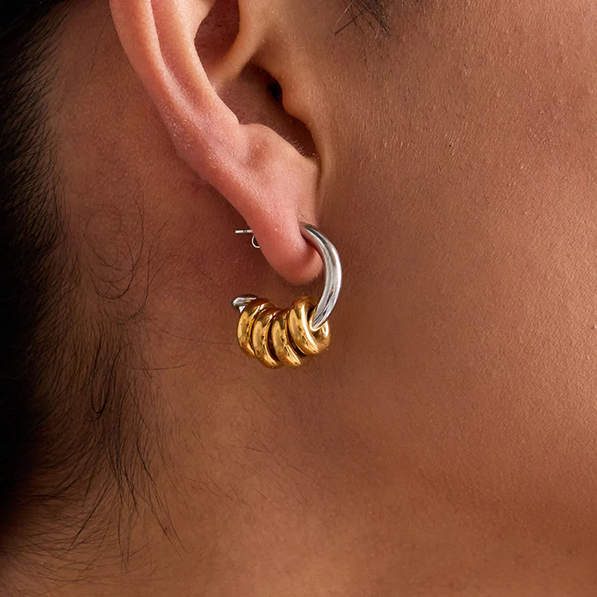 Trendy two-tone hoop earrings featuring intertwined gold and silver designs for a stylish look