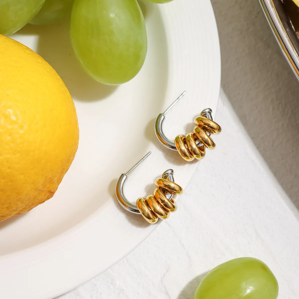 Trendsi two-tone hoop earrings featuring a shiny gold and silver design on a light background