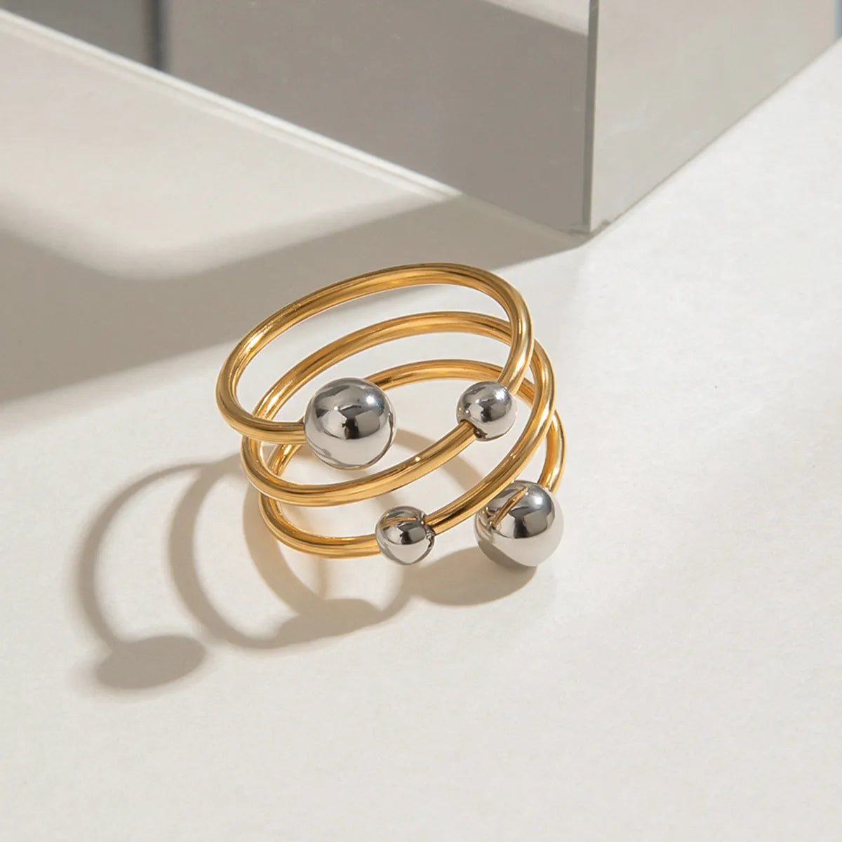 Trendsi two-tone spiral ring featuring gold and silver bands with decorative spheres