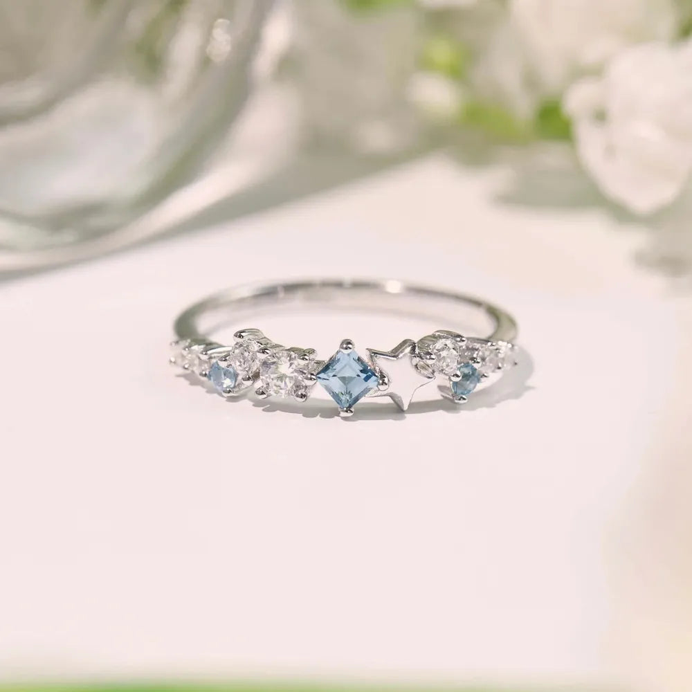 Elegant silver ring featuring a unique star design ring with sparkling blue gemstones