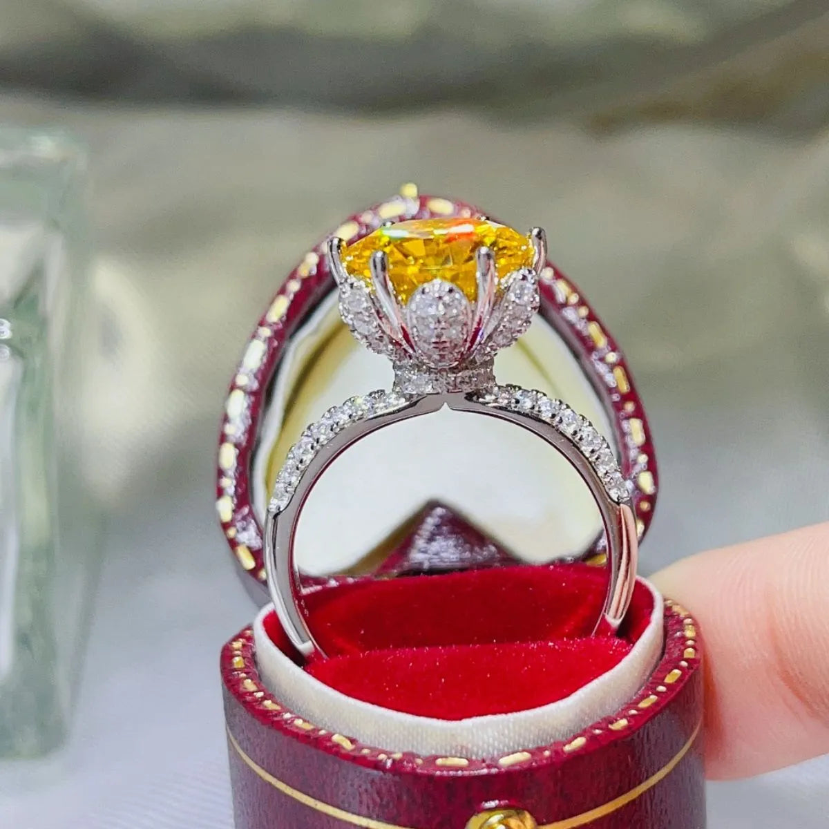 Elegant yellow moissanite ring set in a silver band with sparkling accents in a luxury box