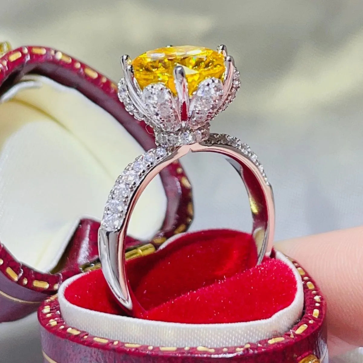 Elegant yellow moissanite ring set in silver with intricate floral design and sparkling accents