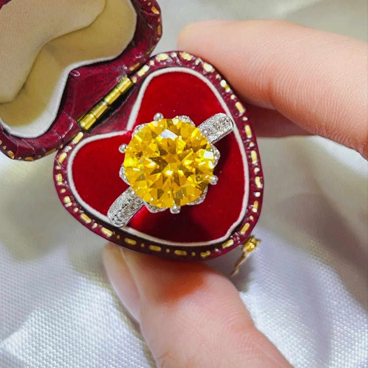 Stunning yellow moissanite ring in a heart-shaped velvet box with sparkling accents