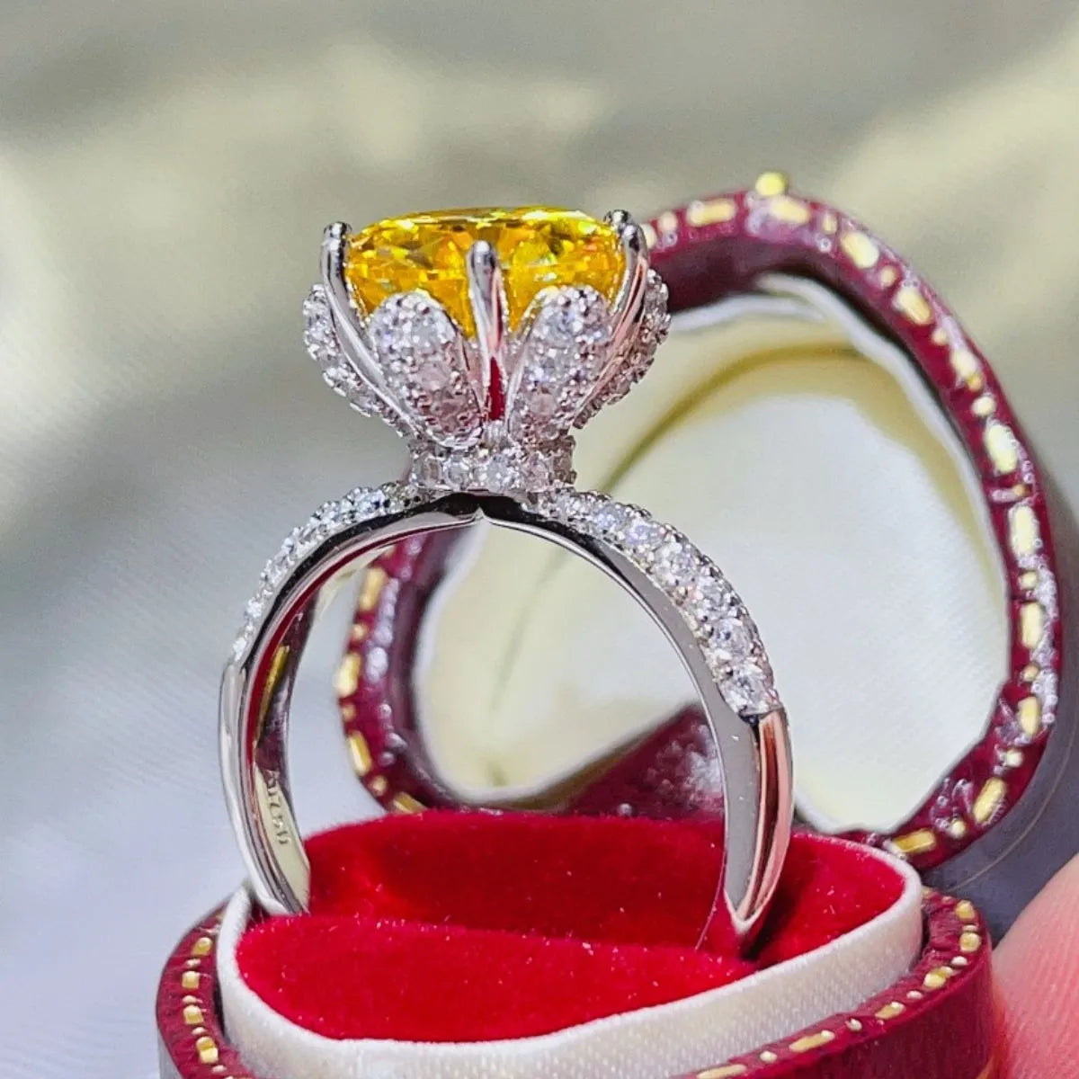 Elegant yellow moissanite ring set in platinum with sparkling diamond accents in a luxury presentation box