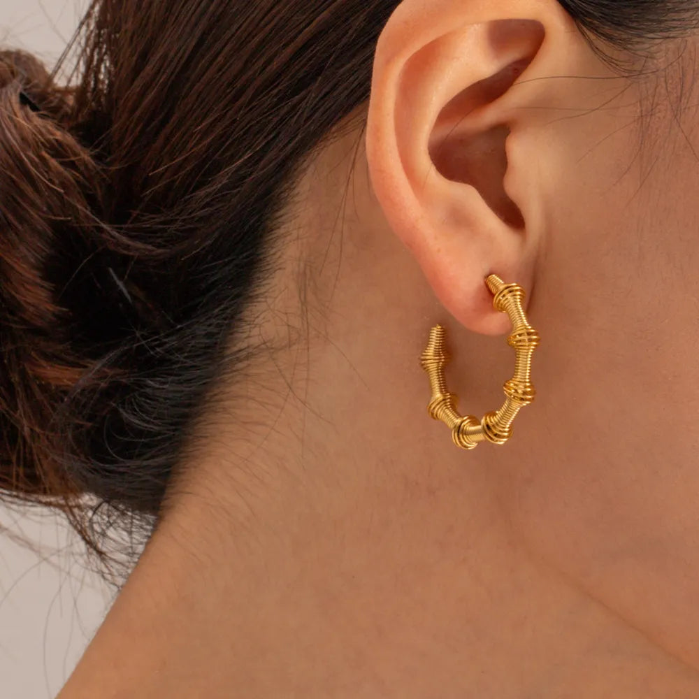 Elegant 18K gold hoop earrings showcasing a unique twisted design for a stylish look
