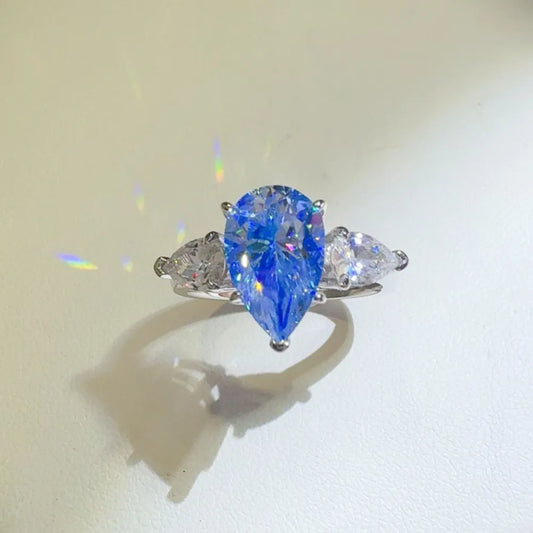 Beautiful 2 carat moissanite teardrop ring with side stones sparkling in sunlight