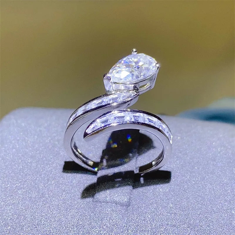 Elegant silver 3 carat moissanite ring with a twist design and sparkling stones on the band