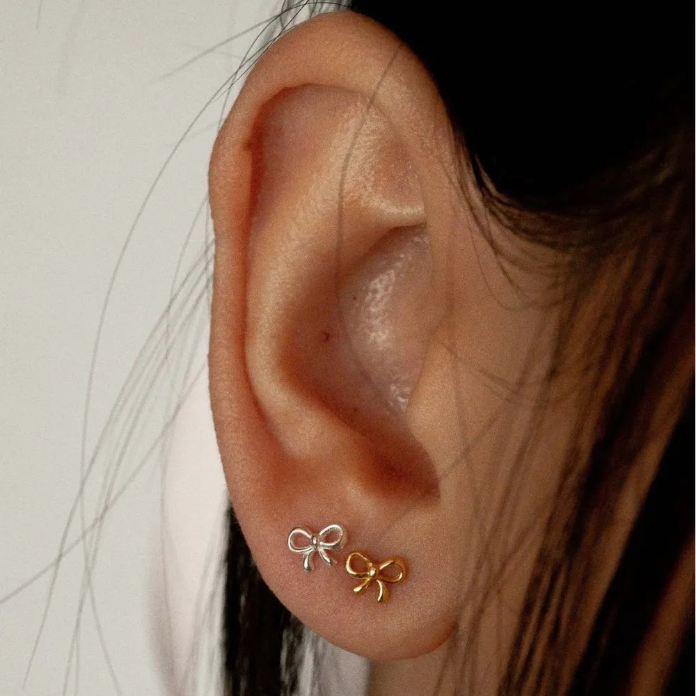 Trendsi copper bow stud earrings elegantly displayed on a model's ear for a stylish look
