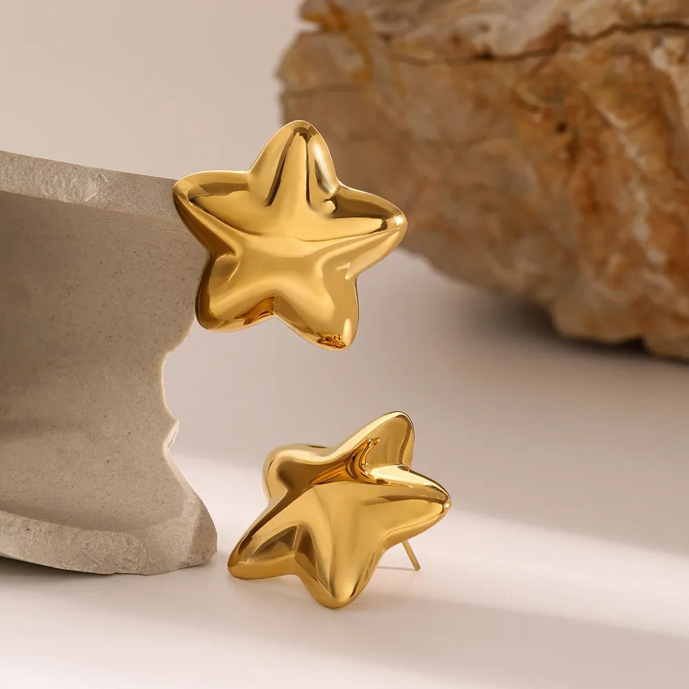 Dazzle collection star earrings in shiny gold with a smooth surface and playful design