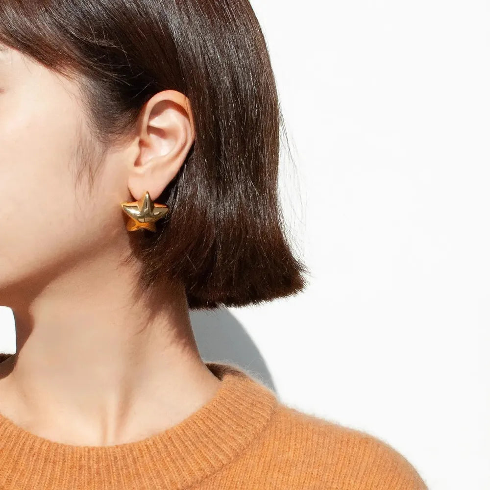 Trendsi Dazzle Collection Star Earrings in Gold Worn by Model with Short Hair