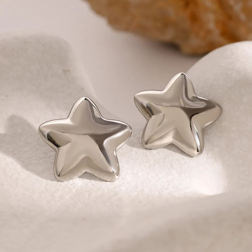 Trendy Dazzle Collection star earrings in shiny silver finish for stylish accessorizing