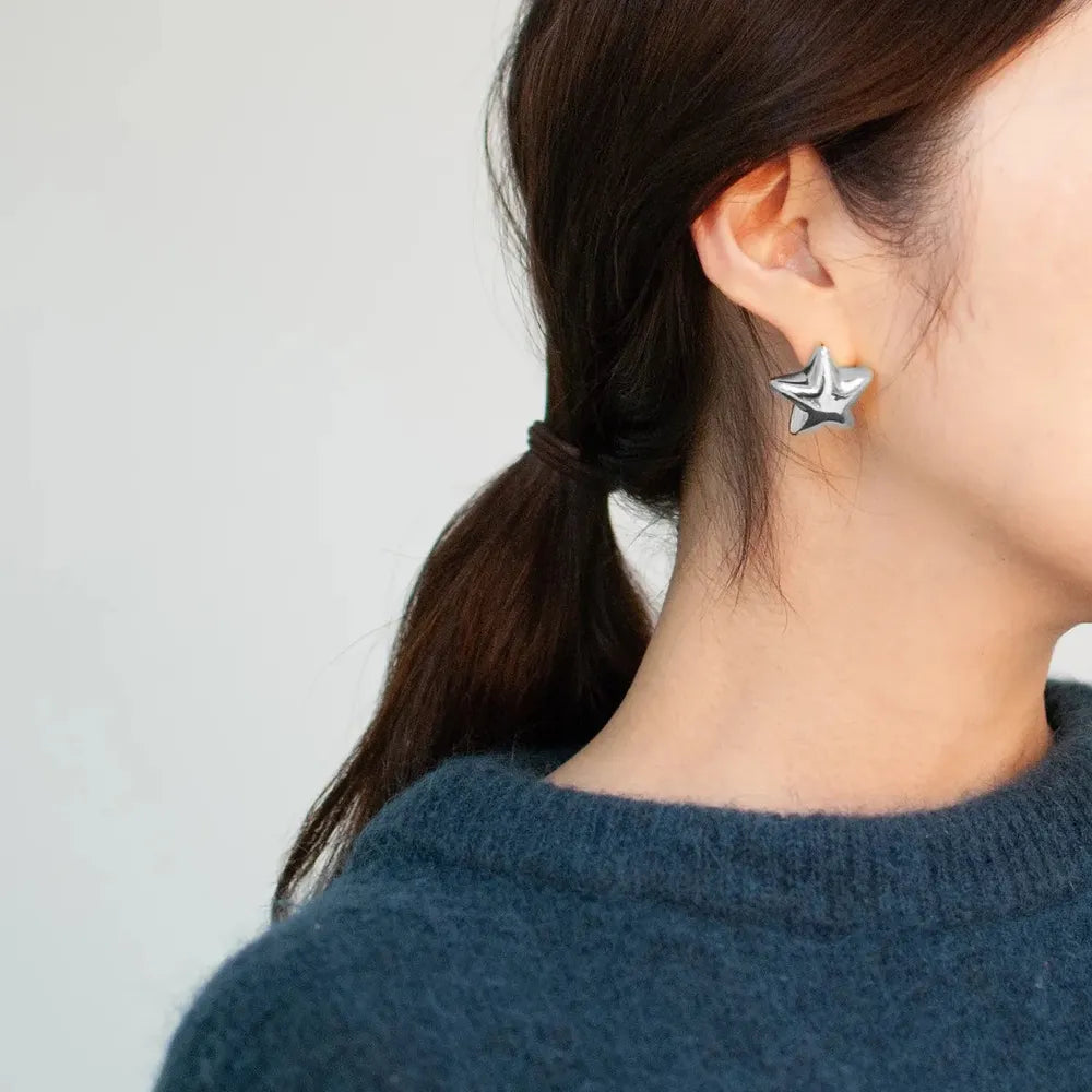 Trendsi Dazzle Collection star earrings in silver worn by a model with a chic hairstyle