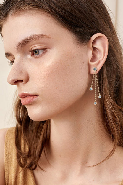 Elegant moissanite drop earrings showcased on a model with a sleek hairstyle and subtle makeup