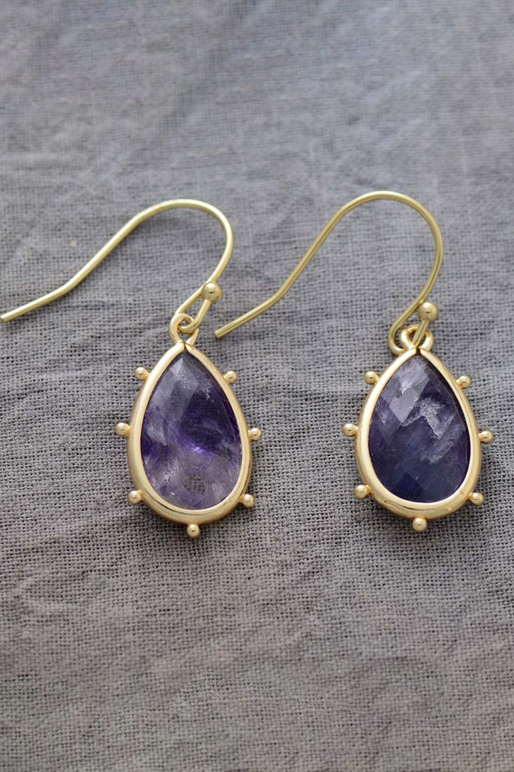 Elegant natural stone earrings featuring a purple teardrop design with gold settings