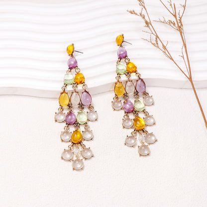 Colorful chandelier earrings featuring red teardrop earrings with vibrant yellow and purple accents