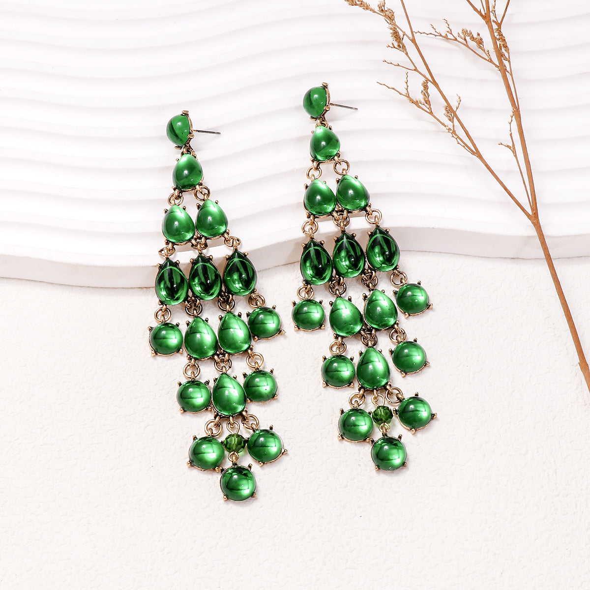 Elegant green teardrop earrings in a cascading design, perfect for formal occasions