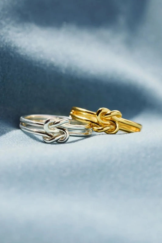 Trendsi silver knot design ring showcased with a gold knot design ring against a soft background