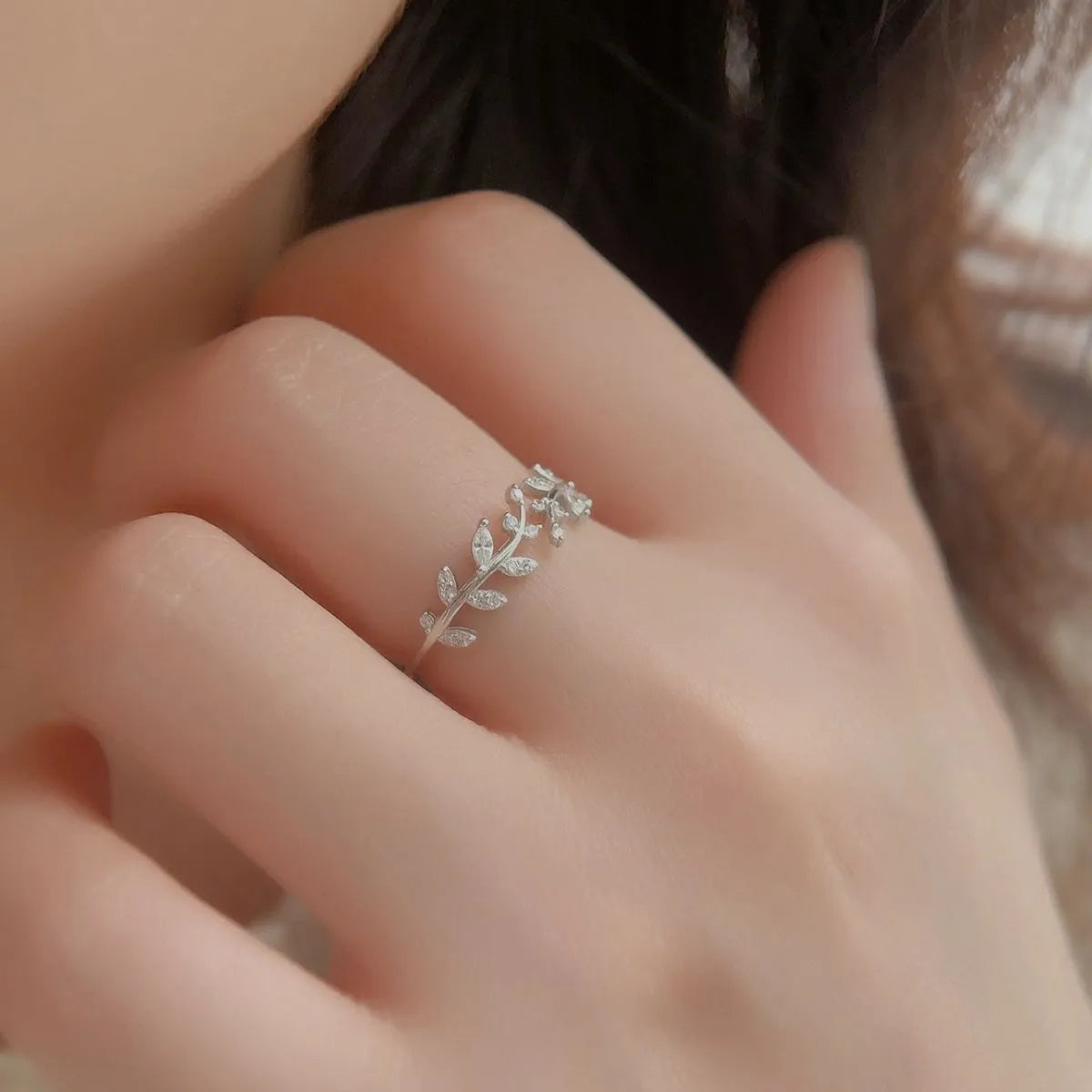 Trendsi stylish summer jewelry featuring a delicate silver leaf ring on a finger