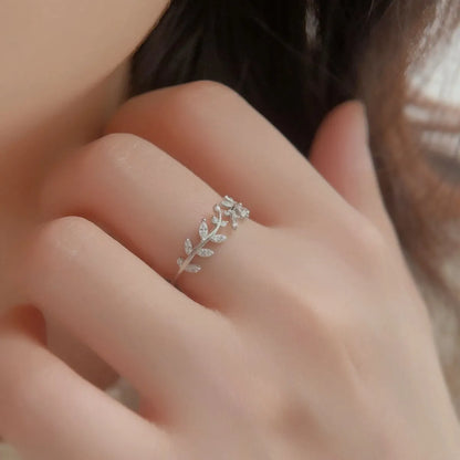 Trendsi stylish summer jewelry featuring a delicate silver leaf ring on a finger