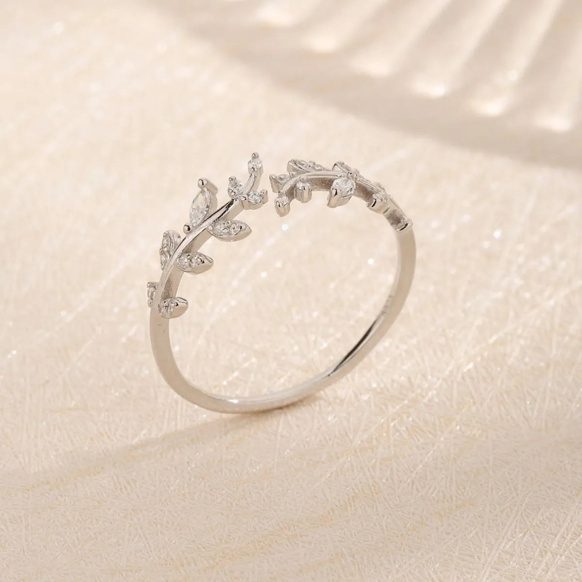 Elegant silver ring with leaf design and sparkling stones, perfect for stylish summer jewelry