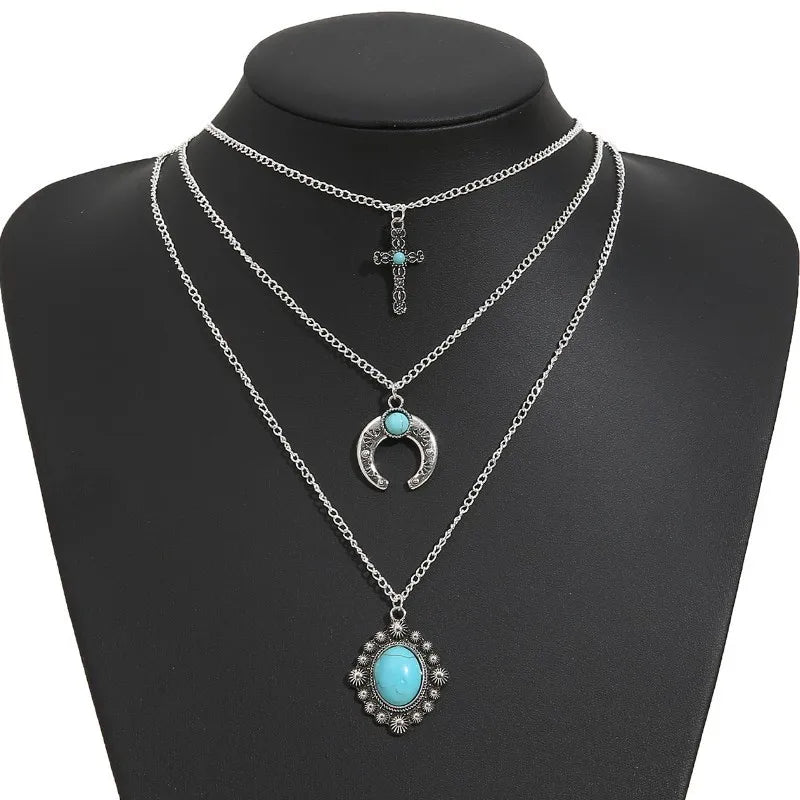 Three-layered turquoise necklace featuring a cross, crescent moon, and a turquoise pendant