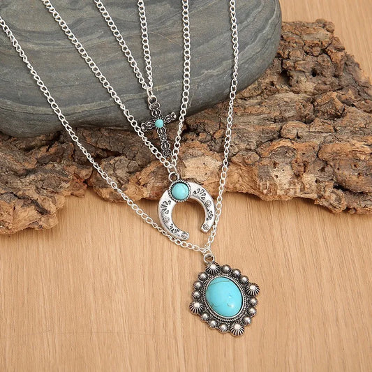 Three-layered turquoise necklace featuring delicate silver chains and unique pendant designs