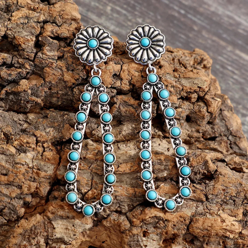 Turquoise teardrop earrings with floral silver accents and stunning turquoise beads