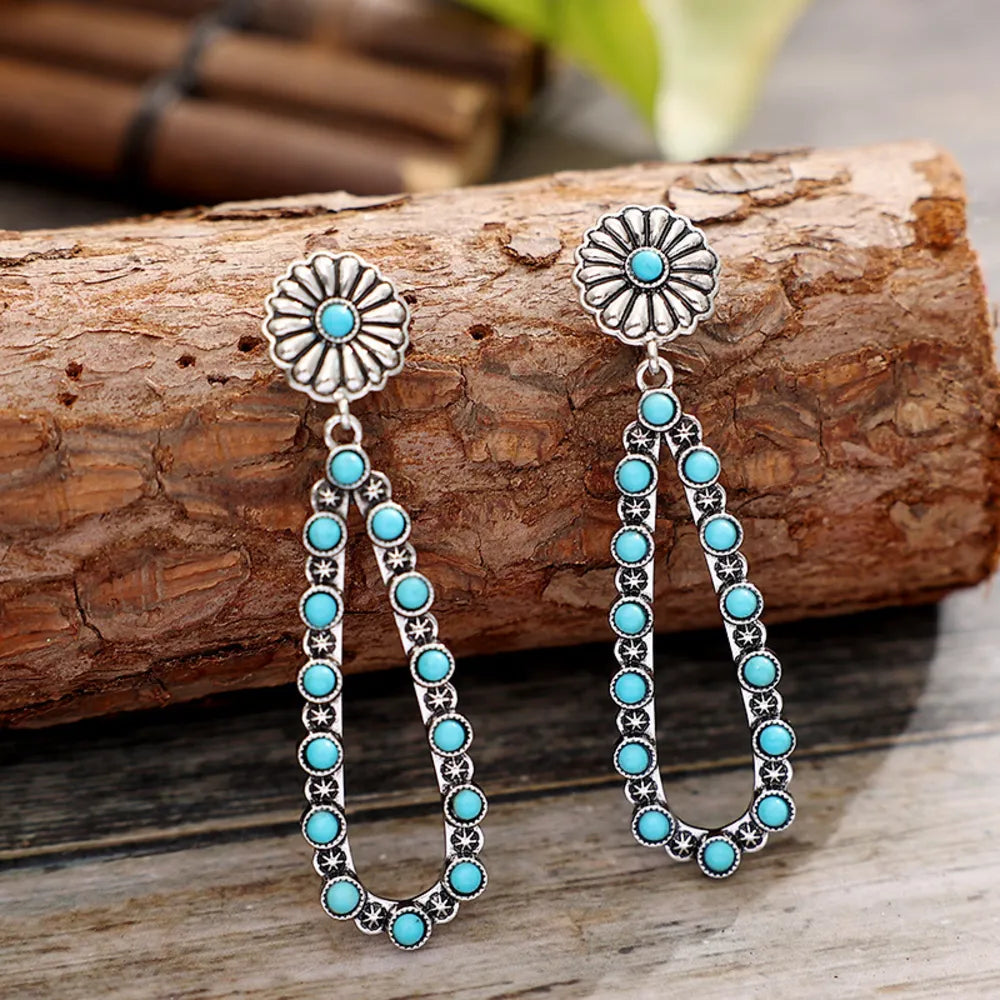 Trendsi turquoise teardrop earrings with detailed silver accents and floral design