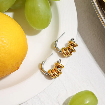 Trendsi two-tone hoop earrings featuring a shiny gold and silver design on a light background
