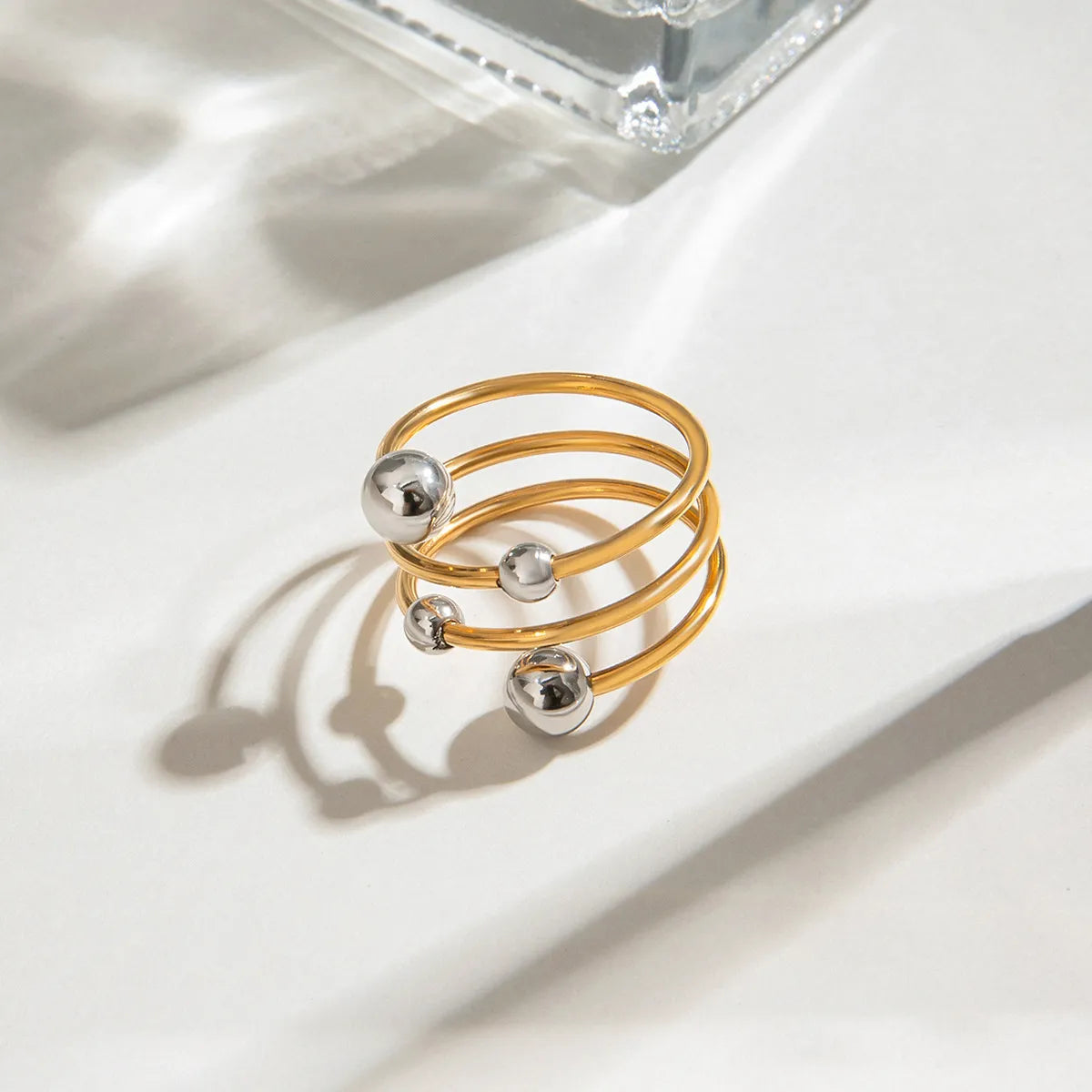 Two-tone spiral ring featuring gold and silver balls for a modern jewelry look