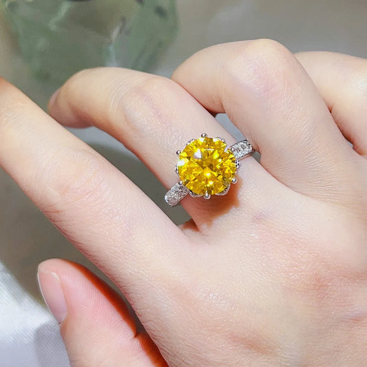 Elegant yellow moissanite ring with a large center stone and sparkling accents on a hand